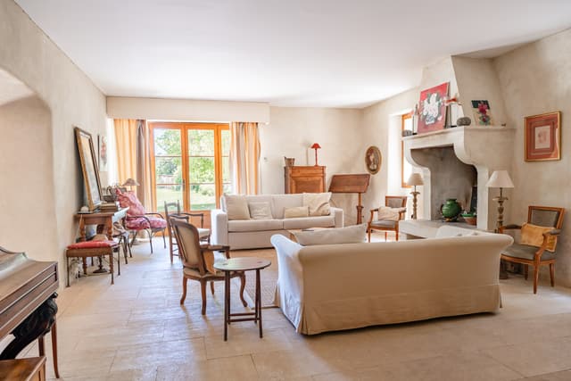 Living room with sofas, fireplace, artwork, and antique furniture